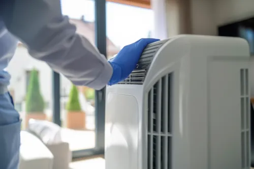 Entretien d'une climatisation mobile en cours par un technicien qualifié.